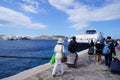 Tourists exiting a ferry and walk onto the dock in Mykonos.