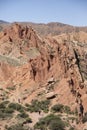 Tourists explore the dramatic landscape of the Fairy Tale Canyon, or Skazka Canyon in Kyrgyzstan