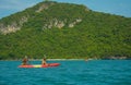 Tourists exploring calm tropical bay with limestone mountains by kayak Royalty Free Stock Photo