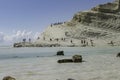 Tourists on limestone coastline with scenic view of the cristal blue ocean in Turks steps in Sicily on a blu sky day