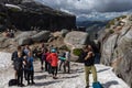 Tourists at the famous boulder Kjeragbolten that is wedged in a mountain crevasse, Norway