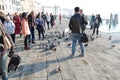 Tourists feed the pigeons in Piazza Venezia, Italy.