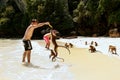 Tourists feeding crab-eating macaques at the beach on Phi Phi Do