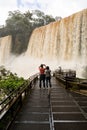 Tourists in the footbridge at iguazu falls veiw from argentina