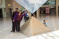 Tourists gather around inverted pyramid in Carrousel de Louvre,