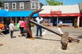 Tourists gather around a large anchor