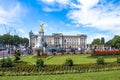 Tourists gather at the gates of Buckingham Palace and the base of the Victoria monument.