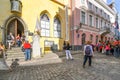 Tourists gather near a street musician performer playing violin in the Old Town center of Medieval Tallinn Estonia