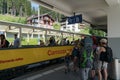 Tourists getting on and off the open panorama carriage of the scenic Chur - Arosa train line in the Swiss Alps Royalty Free Stock Photo