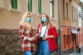 Tourists girls wearing face masks at street. Friends exploring new city together Royalty Free Stock Photo