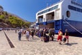 Tourists go to the Blue Star sea ferry on Symi Island