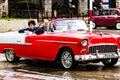 Tourists having a panoramic tour in downtown of Havana city in a Chevrolet Bel Air, a classic American car used as a taxi in