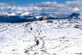 Tourists hike along a snow covered mountain top trail Royalty Free Stock Photo