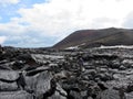 Tourists hiking on black lava and a colorful volcano landscape close to Tolbachik volcano in Kamchatka in Russia