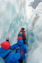 Tourists hiking through the gaps in the ice on Franz Josef Glacier in New Zealand. Royalty Free Stock Photo