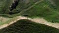 Tourists hiking on summer meadow in green mountain valley, aerial view. Action. People walking on a top of green summer Royalty Free Stock Photo