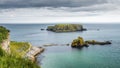 Tourists hiking on trail, with a view on Sheep Island near Carrick a Rede rope bridge, Northern Ireland