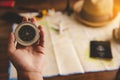 Tourists hold a compass and locate a place on a world map Royalty Free Stock Photo