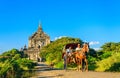 Tourists on horse carts and pagoda, Myanmar