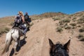 Tourists horse riding through alpine landscape and forest, near Bokonbayevo, Kyrgyzstan