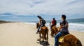 Tourists horseback riding on the beach in Cabo San Lucas, Baja California