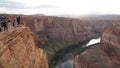 Tourists at the Horseshoe Bend rock formation with steep cliffs rising up from Colorado River in Page, Arizona, USA.