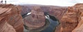 Tourists at the Horseshoe Bend rock formation with steep cliffs rising up from Colorado River in Page, Arizona, USA.