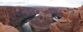 Tourists at the Horseshoe Bend rock formation with steep cliffs rising up from Colorado River in Page, Arizona, USA.