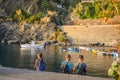 Tourists including a blurred group of young backpackers enjoy a late afternoon at the boat harbor of Vernazza, Italy