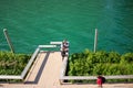 Tourists lean on ledge of pier among floating ecosystem gardens along the Chicago River