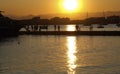 Tourists leave the pleasure boat on the pier in the rays of the golden sunset Royalty Free Stock Photo