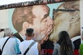 Tourists at Leonid Brezhnev and Erich Honecker kissing mural painting. East side Gallery. Berlin. Germany