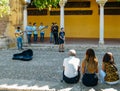 Tourists listen to a live flamenco-style music performance in the historic centre of Cordoba, Andalucia, Spain - UNESCO