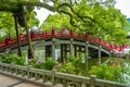 Tourists and local japanese people walk across the beautiful red bridge leading to the famous Tenmangu Shrine in Dazaifu, Japan Royalty Free Stock Photo