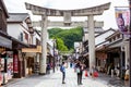 Tourists and local japanese people walk along the main road, surrounded by shops, leading to the famous Tenmangu Shrine in Dazaifu