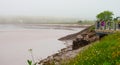 Tourists and local people observe the tidal bore roll into Moncton, New Brunswick, Canada. Royalty Free Stock Photo