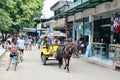 Tourists, locals, bicycles, carriages, and horses mixed in the sand promenade that rounds the largest Gili Island.