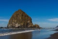 Tourists and locals enjoying the beach with Haystack Rock in the background at Cannon beach, Oregon, USA. Royalty Free Stock Photo