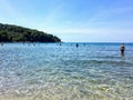 Tourists and locals enjoying the beautiful clear waters off the shores of Korcula Island at vela przina beach