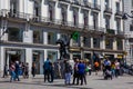Tourists and locals at the famous Puerta del Sol square looking at the iconic statue of the Bear and