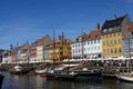 Tourists and locals walk down the waterfront street along colorful row houses. Royalty Free Stock Photo