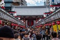 Tourists and locals walking in Senso-ji temple market street facing to the lanternt at the entrance