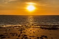 tourists and locals walking at sunset on the beach in Broome and enyoing sunset, with a big ship at the horizon, Western Australia