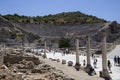 Tourists look around the columns, ruins and amphitheater of the