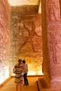 Tourists look at a hieroglyph wall inside Abu Simbel