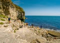 Tourists look out to the sea from the rocky Dancing Ledge, Langton Matravers, near Swanage, Dorset, UK Royalty Free Stock Photo