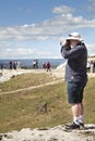 Tourists looking with binoculars Roman amphitheater. Syracuse, Sicily. Italy.