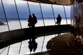 Tourists looking down through big windows to see town of seattle from Space Needle