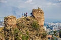 Tourists looking down who climbed ruins at Narikala- an ancient fortress overlooking the capital of