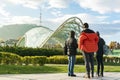 Tourists looking at famous Tbilisi bridge of peace and high tv tower in the background on the hill